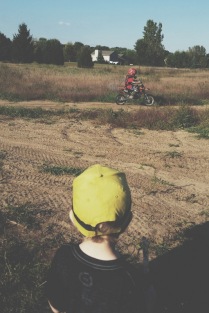 Watching the boys dirt bike. He tried his hand at it earlier and has yet to become a fan of it.